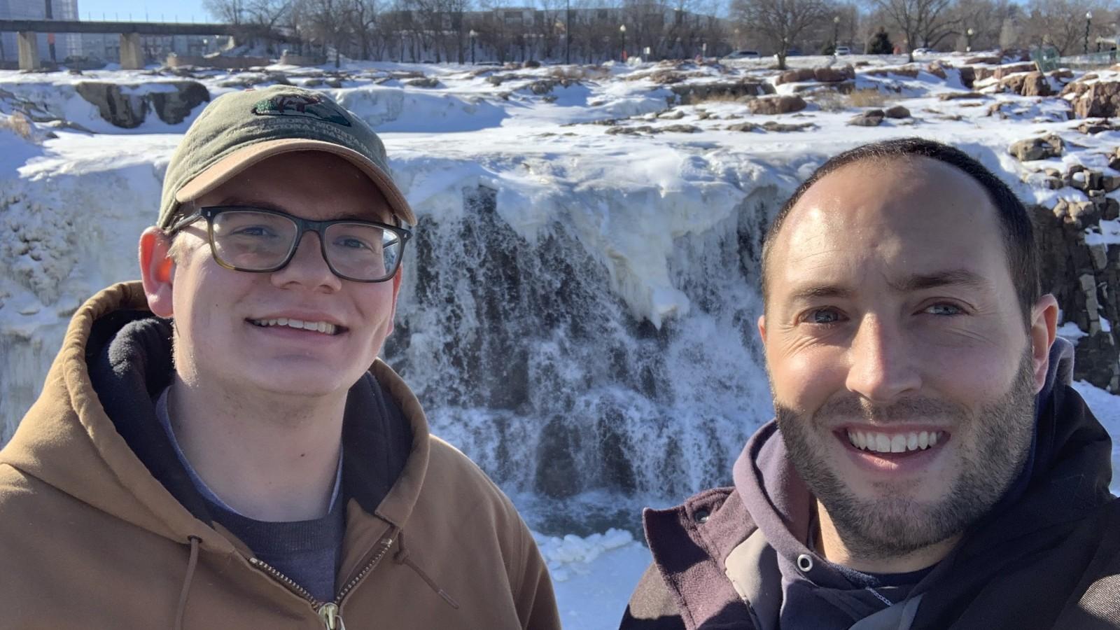 Jacob Bentley and Steven Gratz in front of a frozen Sioux Falls