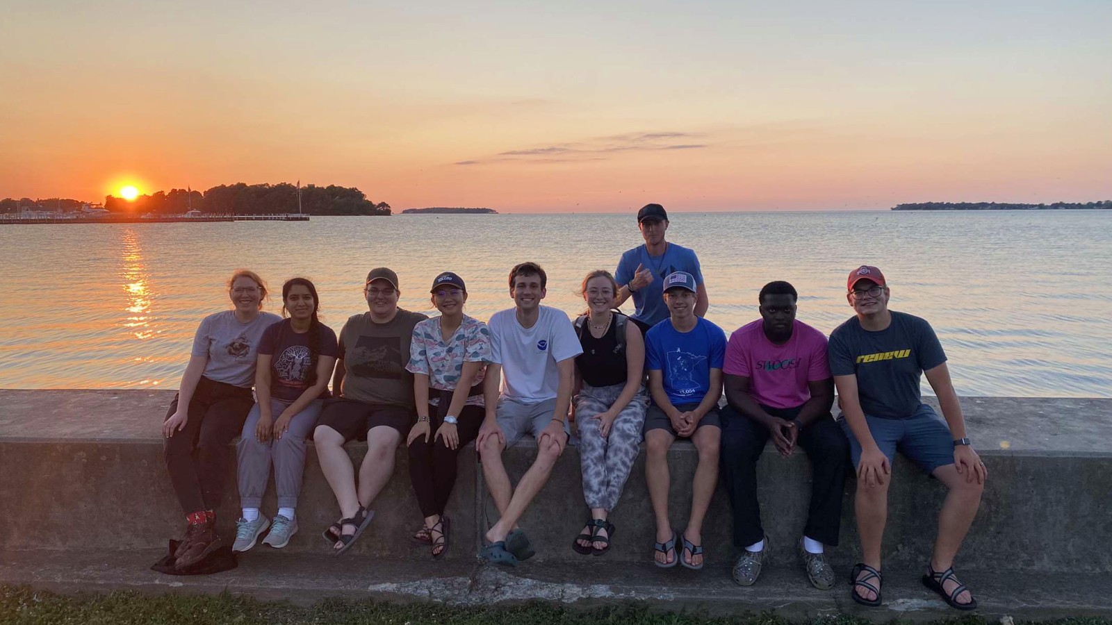 Some of the student participants in front of a Lake Erie sunset