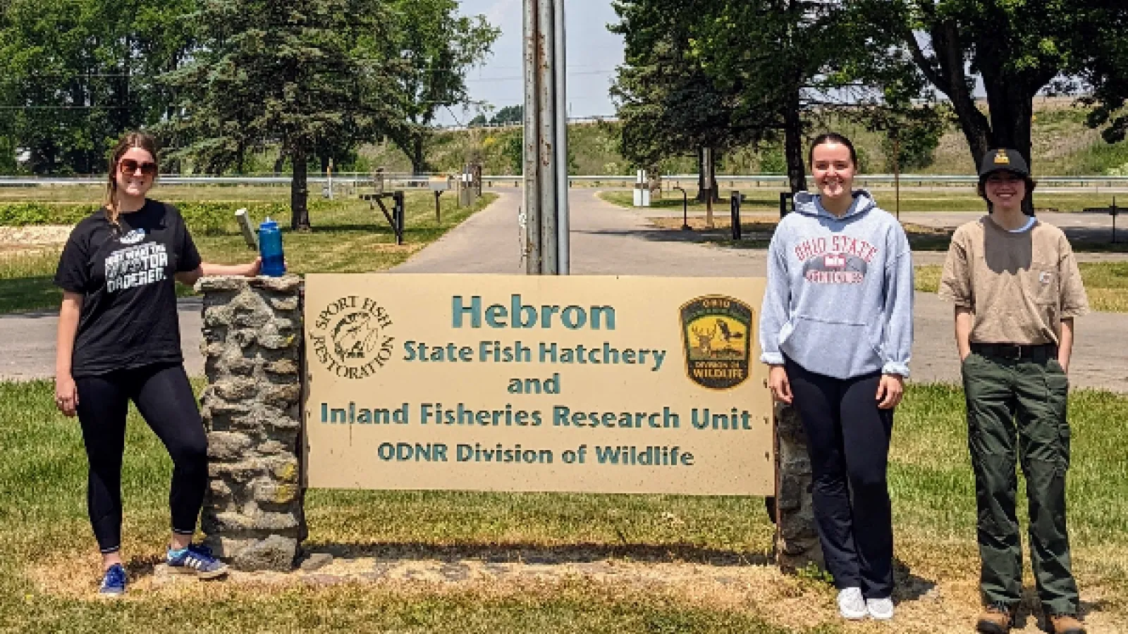 Marley, Olivia, and Jay by the Hebron State Fish Hatchery Sign