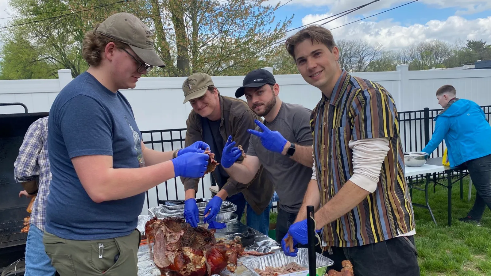 Jacob, Sawyer, Matt, and Neil processing the cooked pig