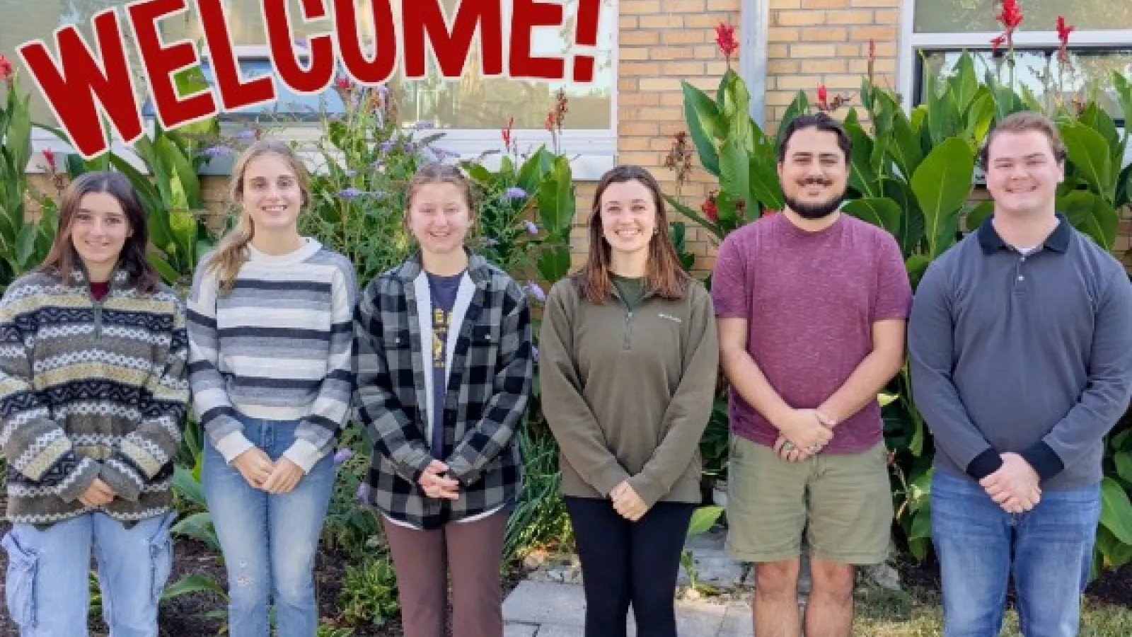 Group photo of new AELers with text "Welcome!" in red above them