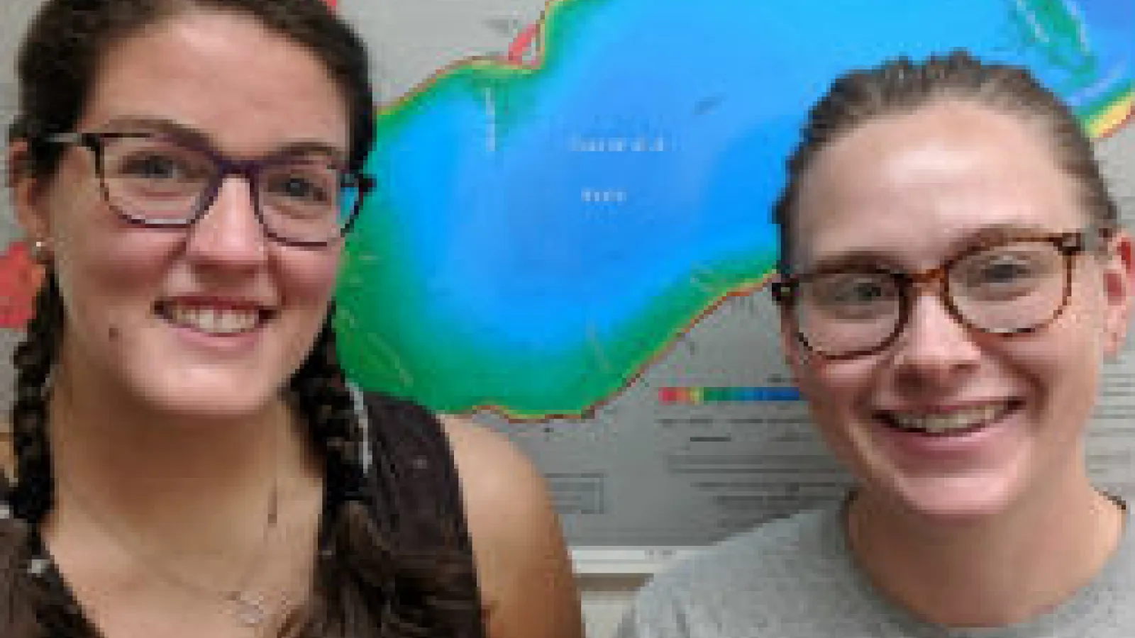 Rachel Finigan and Hannah Moore stand in front of a map of Lake Erie