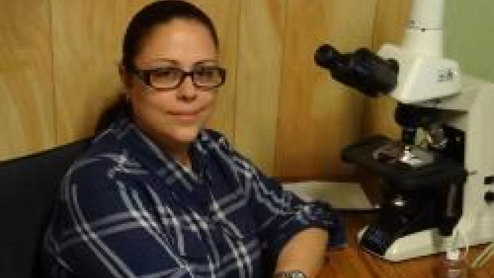 Dr. Nevine Abou Shabana in front of a microscope