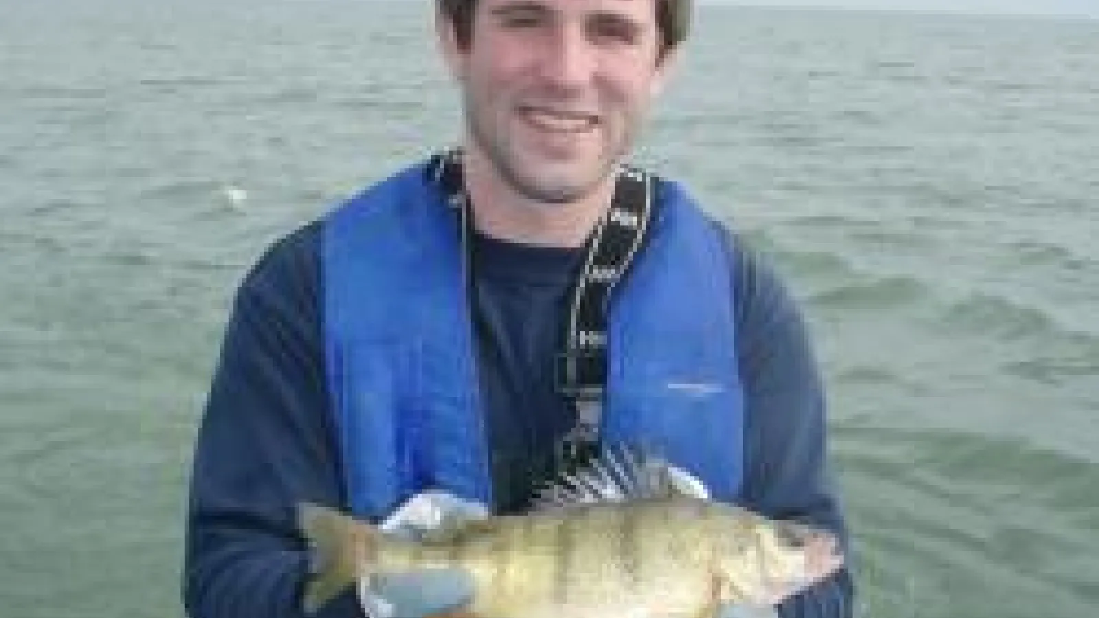 Troy Farmer holding a yellow perch on a boat
