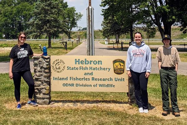Marley, Olivia, and Jay by the Hebron State Fish Hatchery Sign