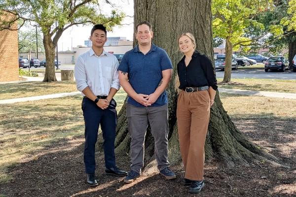 Hwan Chen, Mike Figueroa, and Kendall Ashley in front of a tree