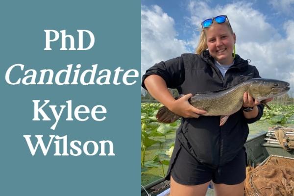 Text: "PhD Candidate Kylee Wilson", the word "candidate" is italicized for emphasis; headshot of Kylee Wilson holding a bowfin