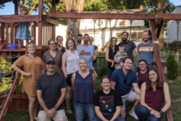 Group photo of AEL members in front of a backyard play set