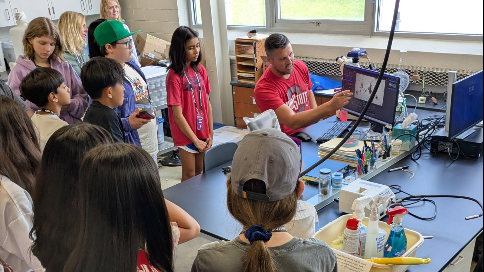 Mike Kulasa shows students what he is looking at under a microscope
